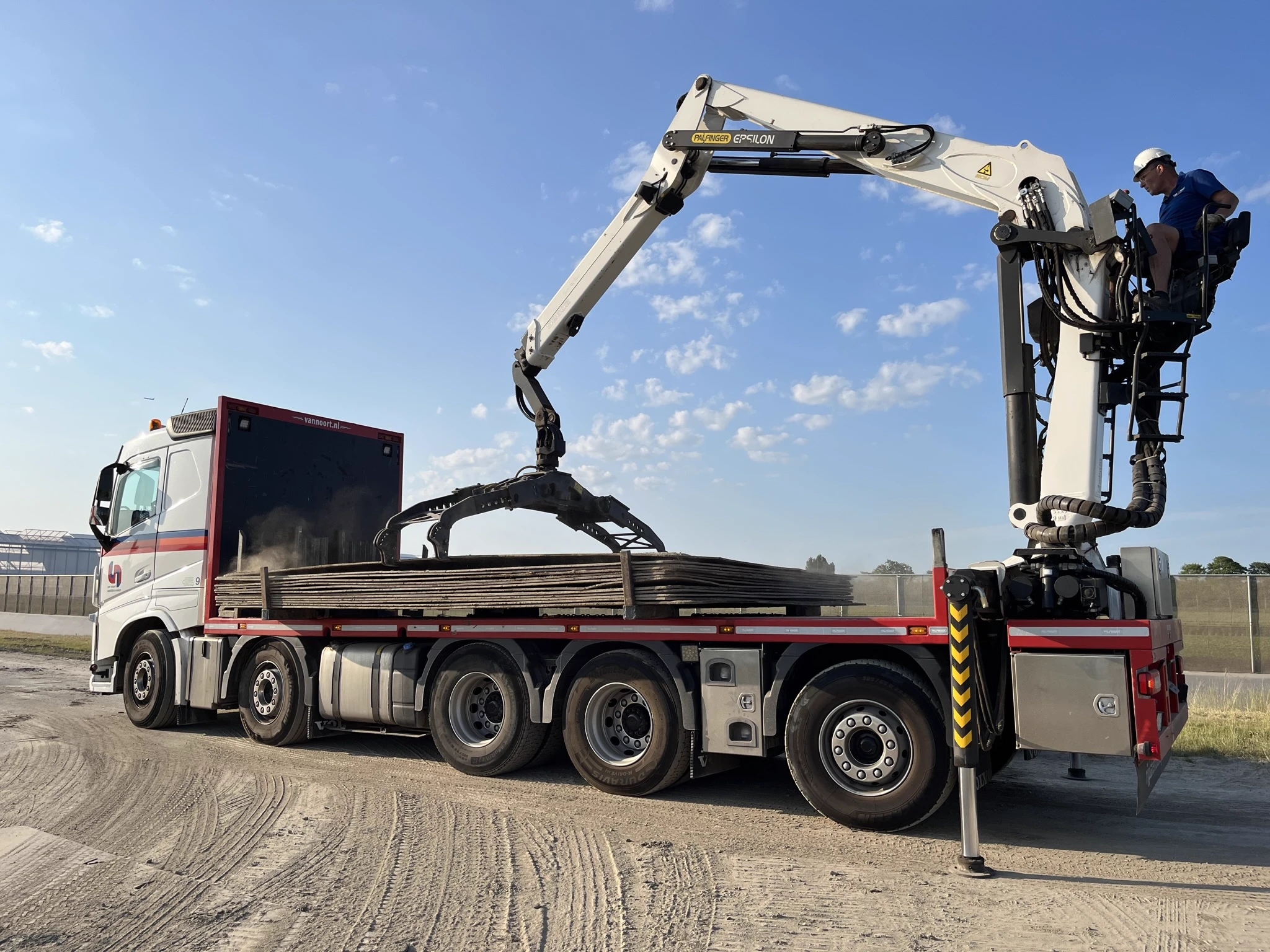 Rijplatenwagen van Van Noort met een lading stalen rijplaten en de grijper van de kraan