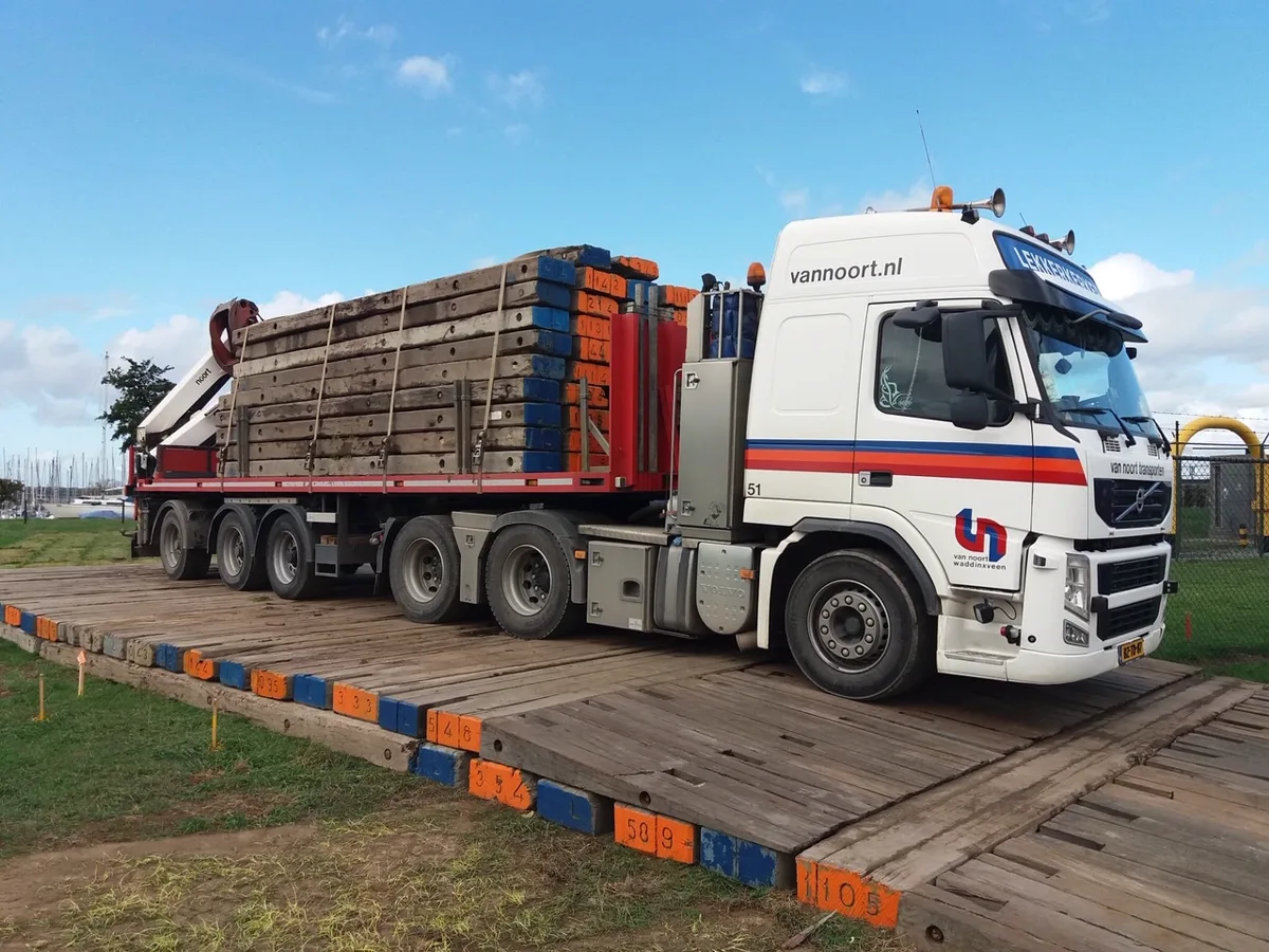 Van Noort-vrachtwagen met een lading houten draglineschotten rijdt over een rijbaan van draglineschotten